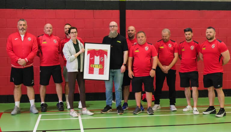 Coaches from St Columbans gifting jersey to Michael Burke from Stira